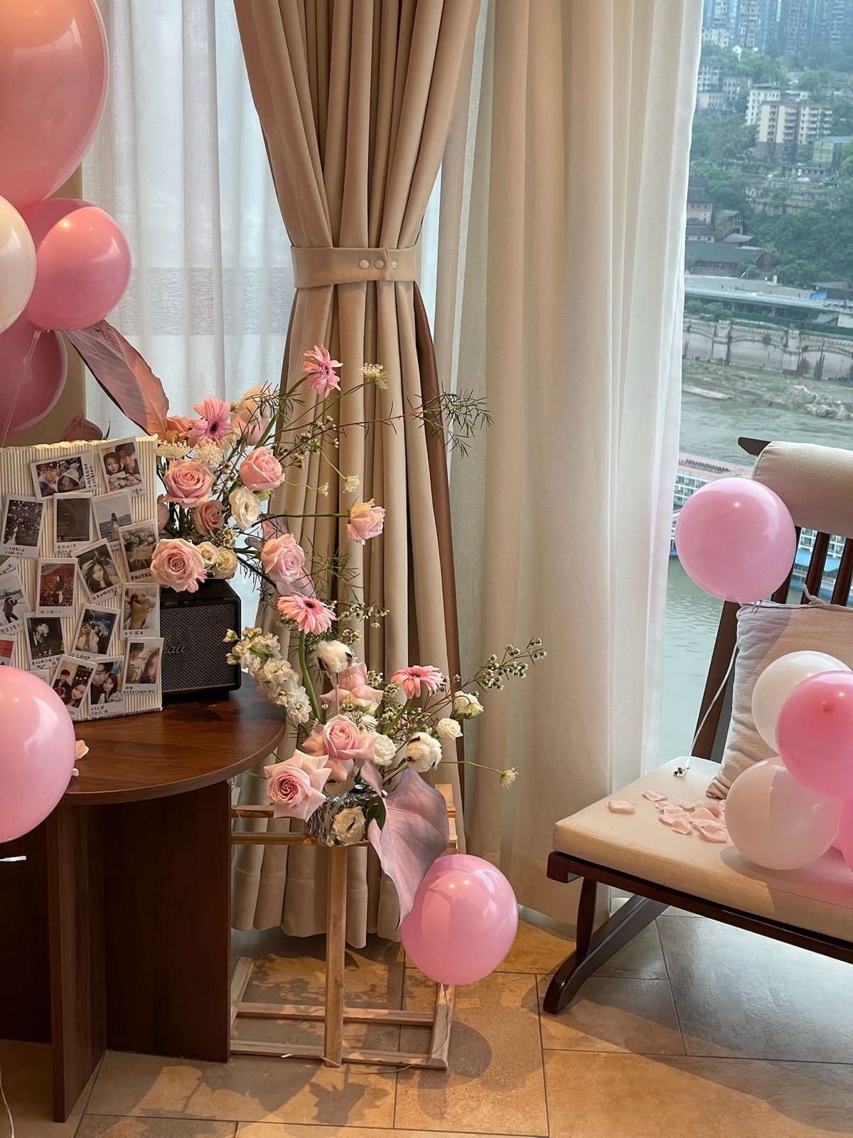 Pink flowers and balloons prepared for a celebration in a guest room