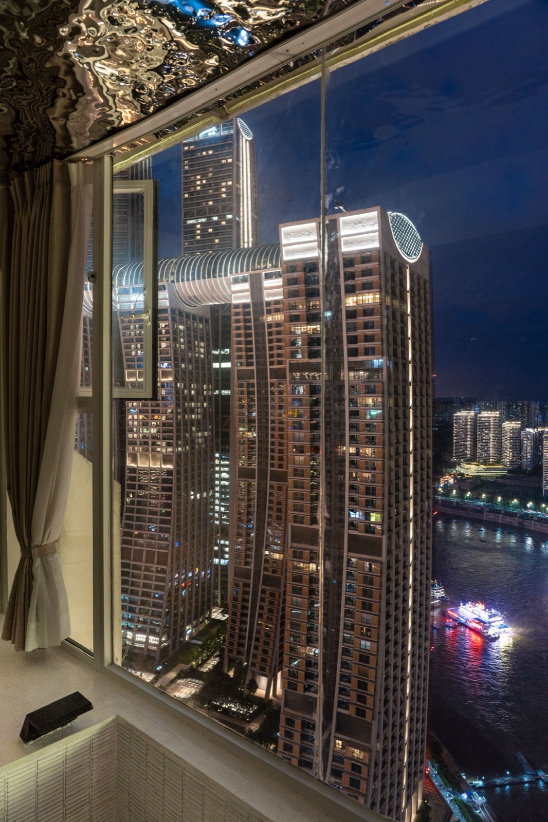 Raffles City Chongqing illuminated at night, seen from a guest room